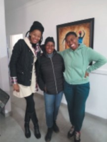 Three women smiling together indoors